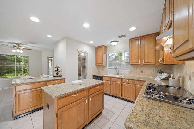 8602 Canyon Pine Dr, Spring, TX 77379 - kitchen with a sink, gas cooktop, under cabinet range hood, a center island, and light tile patterned floors