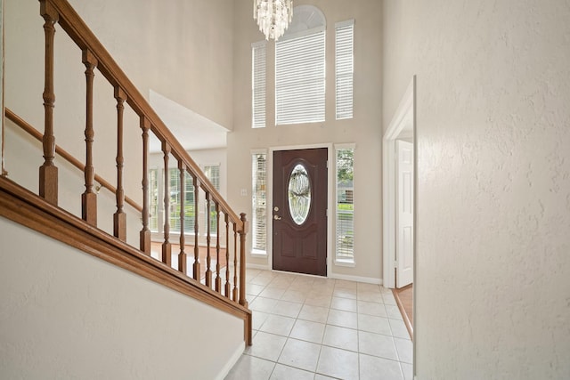 8602 Canyon Pine Dr, Spring, TX 77379 - entryway featuring stairs, light tile patterned floors, a chandelier, baseboards, and a towering ceiling