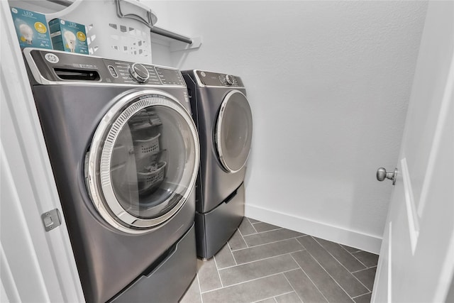 312 Tallow Dr, Conroe, TX 77385 - laundry area with washer and dryer, tile patterned flooring, and baseboards