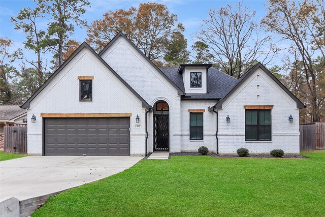 312 Tallow Dr, Conroe, TX 77385 - view of front of house featuring brick siding, driveway, a shingled roof, and a garage