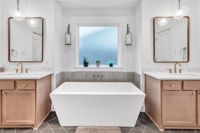 312 Tallow Dr, Conroe, TX 77385 - full bathroom featuring two vanities, a soaking tub, and tile patterned flooring