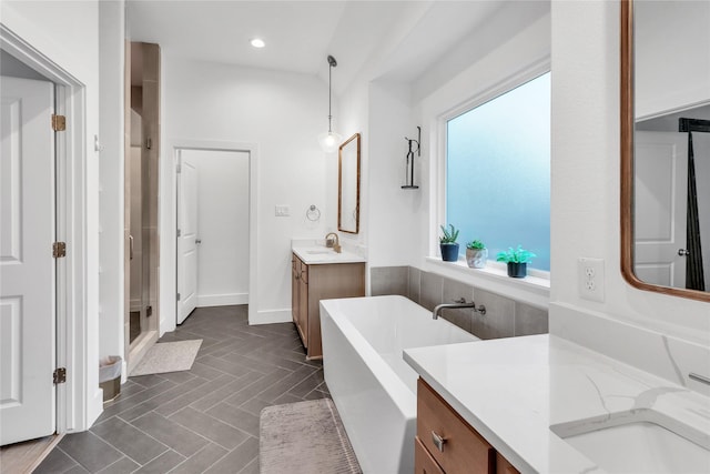 312 Tallow Dr, Conroe, TX 77385 - bathroom with a shower stall, a freestanding bath, two vanities, recessed lighting, and baseboards