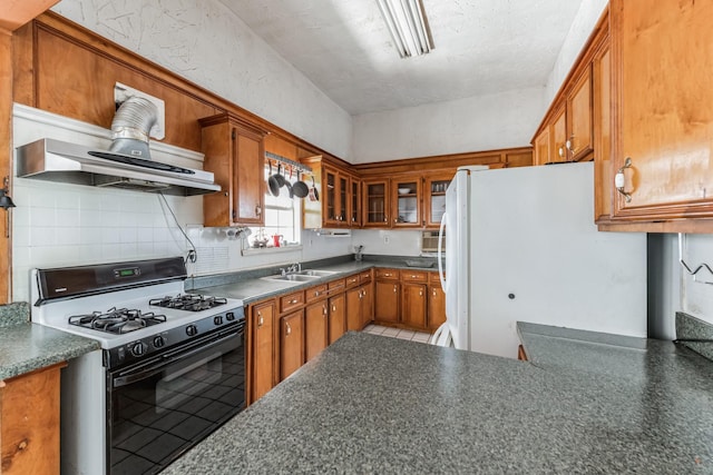 2009 Chestnut St, Houston, TX 77009 - kitchen with gas stove, freestanding refrigerator, brown cabinets, tasteful backsplash, and dark countertops