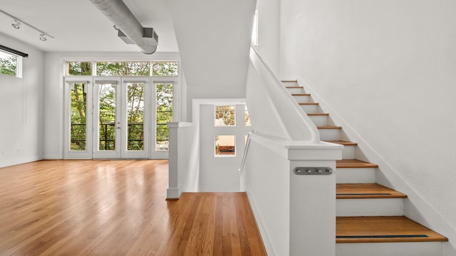2436 Bissonnet St Unit 8, Houston, TX 77005 - staircase with wood finished floors, rail lighting, and baseboards