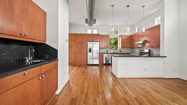 2436 Bissonnet St Unit 8, Houston, TX 77005 - kitchen with appliances with stainless steel finishes, a sink, dark countertops, under cabinet range hood, and brown cabinets