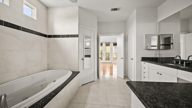 2436 Bissonnet St Unit 8, Houston, TX 77005 - bathroom with healthy amount of natural light, a jetted tub, vanity, and tile patterned floors