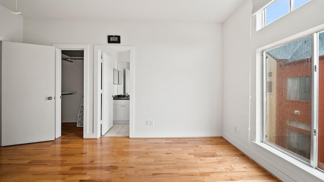 2436 Bissonnet St Unit 8, Houston, TX 77005 - unfurnished bedroom featuring light wood-style flooring, a spacious closet, connected bathroom, and baseboards