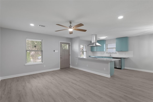 9827 Shive Dr, Houston, TX 77078 - kitchen featuring island exhaust hood, light countertops, blue cabinets, light wood-type flooring, and a ceiling fan