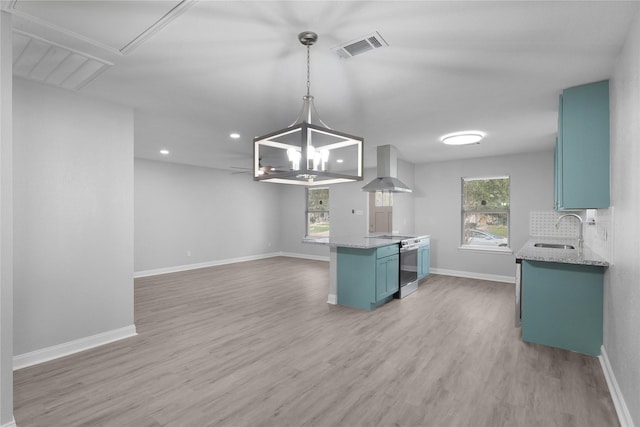 9827 Shive Dr, Houston, TX 77078 - kitchen featuring wall chimney exhaust hood, stainless steel range with electric cooktop, a sink, blue cabinets, and light wood-style flooring