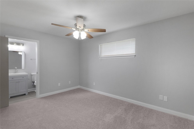 9827 Shive Dr, Houston, TX 77078 - unfurnished bedroom featuring light colored carpet, baseboards, ensuite bathroom, and ceiling fan