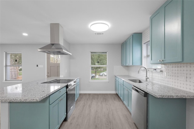9827 Shive Dr, Houston, TX 77078 - kitchen with appliances with stainless steel finishes, ventilation hood, a sink, blue cabinetry, and recessed lighting
