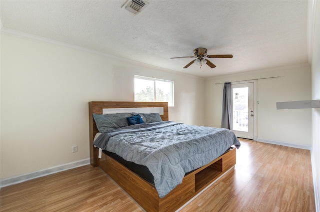 10102 Kirkvale Dr, Houston, TX 77089 - bedroom with multiple windows, crown molding, light wood-style flooring, access to exterior, and a textured ceiling