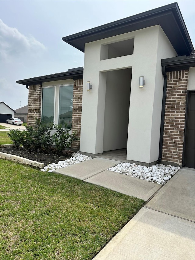 14007 Valley Creek Ct, Conroe, TX 77384 - entrance to property with brick siding, stucco siding, and a lawn
