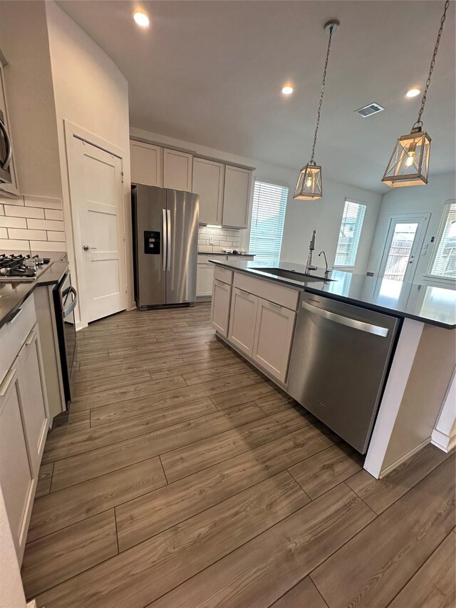 14007 Valley Creek Ct, Conroe, TX 77384 - kitchen with appliances with stainless steel finishes, dark countertops, backsplash, dark wood finished floors, and recessed lighting