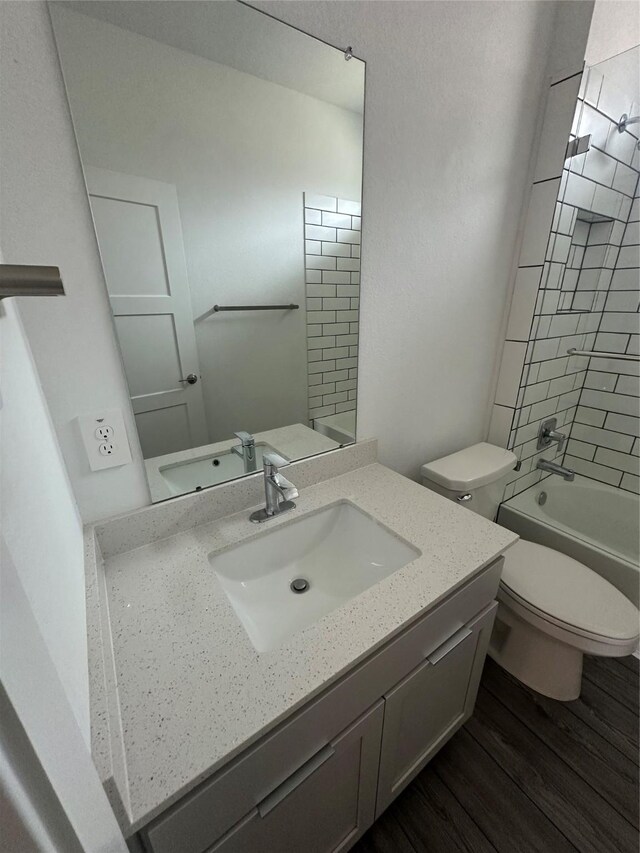 14007 Valley Creek Ct, Conroe, TX 77384 - bathroom featuring toilet, wood finished floors, vanity, and shower / bath combination
