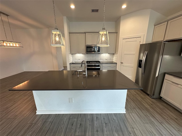 14007 Valley Creek Ct, Conroe, TX 77384 - kitchen with appliances with stainless steel finishes, dark countertops, backsplash, dark wood-style floors, and recessed lighting