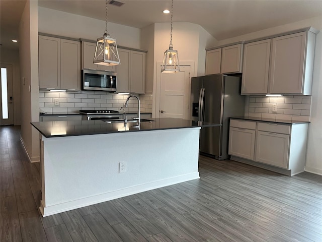 14007 Valley Creek Ct, Conroe, TX 77384 - kitchen with stainless steel appliances, a sink, dark countertops, gray cabinets, and tasteful backsplash