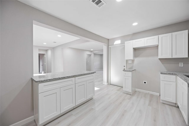 4114 Hoffman St, Houston, TX 77026 - kitchen featuring light stone counters, white cabinetry, baseboards, and recessed lighting