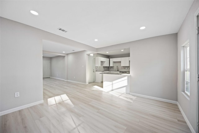4114 Hoffman St, Houston, TX 77026 - unfurnished living room featuring baseboards, a sink, recessed lighting, and light wood-style flooring