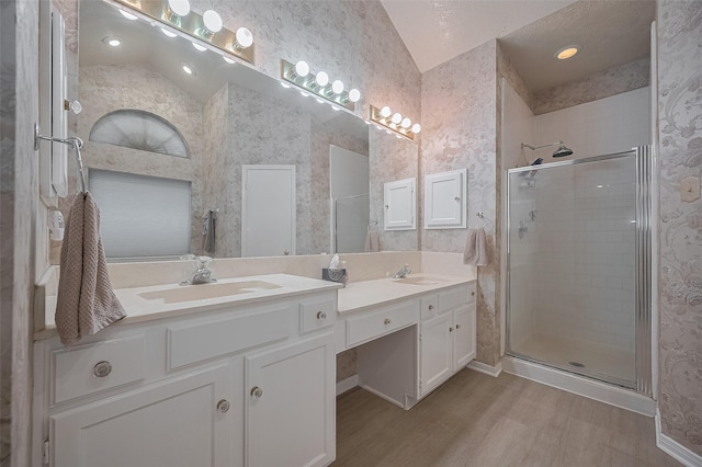 20011 Doherty Cir, Katy, TX 77449 - full bathroom with wood finished floors, vaulted ceiling, a stall shower, double vanity, and wallpapered walls