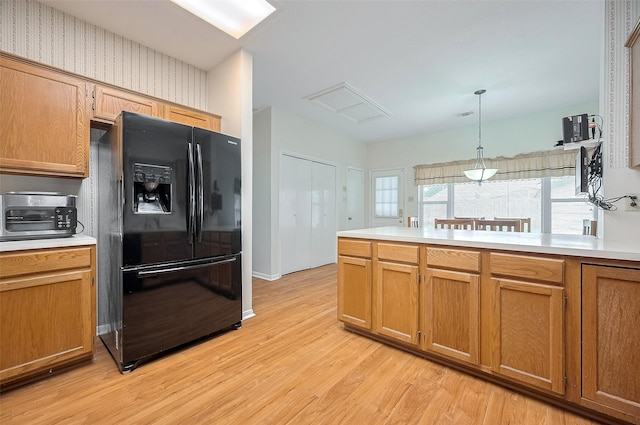 20011 Doherty Cir, Katy, TX 77449 - kitchen with black fridge with ice dispenser, light wood-style floors, light countertops, and pendant lighting