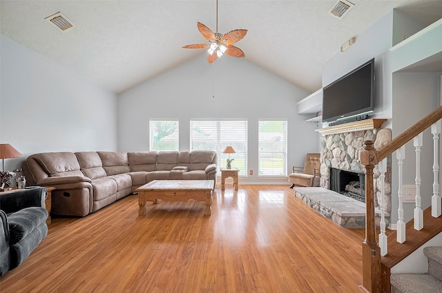 20011 Doherty Cir, Katy, TX 77449 - living area with light wood-style flooring, stairs, ceiling fan, a fireplace, and high vaulted ceiling