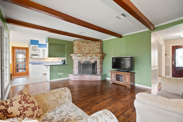 111 Whispering Oaks Dr, Seabrook, TX 77586 - living area featuring beamed ceiling, wood-type flooring, a fireplace, and baseboards