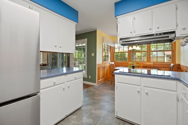 111 Whispering Oaks Dr, Seabrook, TX 77586 - kitchen featuring freestanding refrigerator, under cabinet range hood, white cabinets, and dark countertops