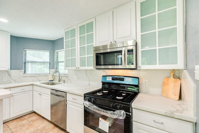 411 Southern Oaks Dr, Lake Jackson, TX 77566 - kitchen with appliances with stainless steel finishes, white cabinetry, a sink, glass insert cabinets, and light stone counters