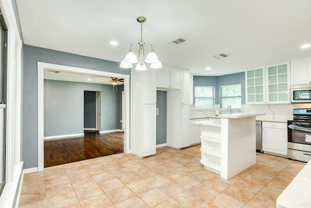 411 Southern Oaks Dr, Lake Jackson, TX 77566 - kitchen featuring stainless steel appliances, light countertops, white cabinets, glass insert cabinets, and recessed lighting