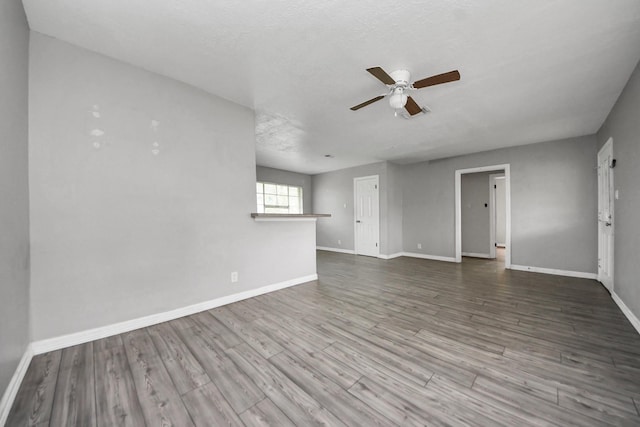 141 E Twickenham Trl, Houston, TX 77076 - unfurnished living room with a ceiling fan, baseboards, and wood finished floors