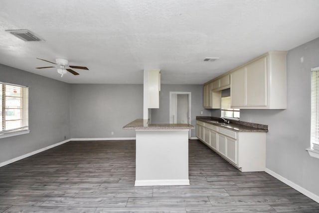 141 E Twickenham Trl, Houston, TX 77076 - kitchen with a sink, a ceiling fan, baseboards, and a peninsula