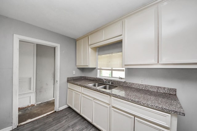 141 E Twickenham Trl, Houston, TX 77076 - kitchen featuring a sink, dark wood-type flooring, dark countertops, and baseboards