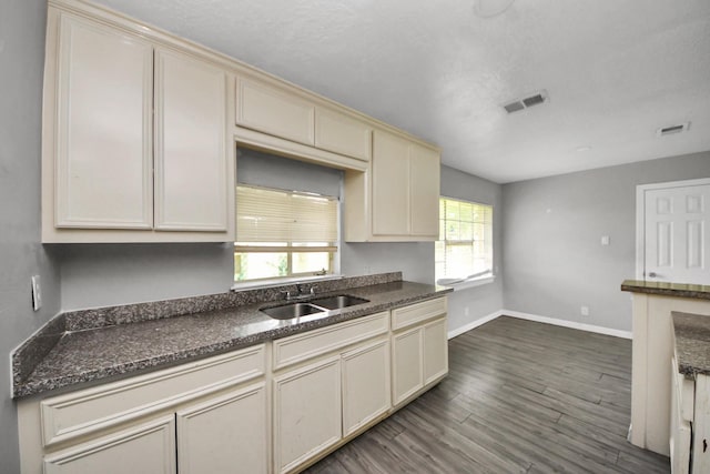 141 E Twickenham Trl, Houston, TX 77076 - kitchen featuring cream cabinetry, a sink, dark wood-type flooring, and baseboards