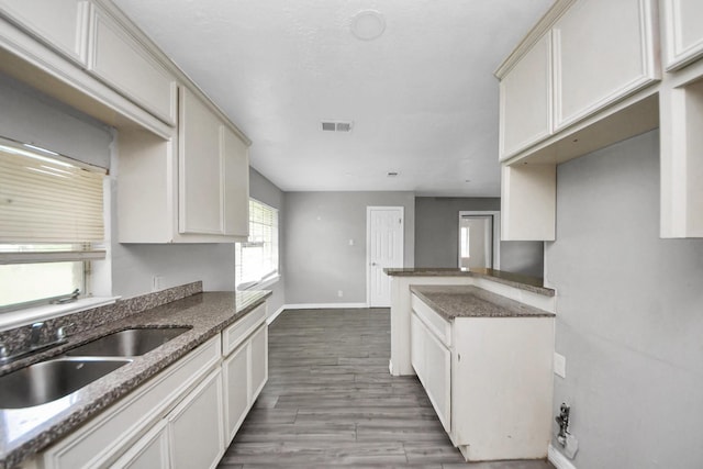 141 E Twickenham Trl, Houston, TX 77076 - kitchen with a sink, dark stone countertops, baseboards, and wood finished floors