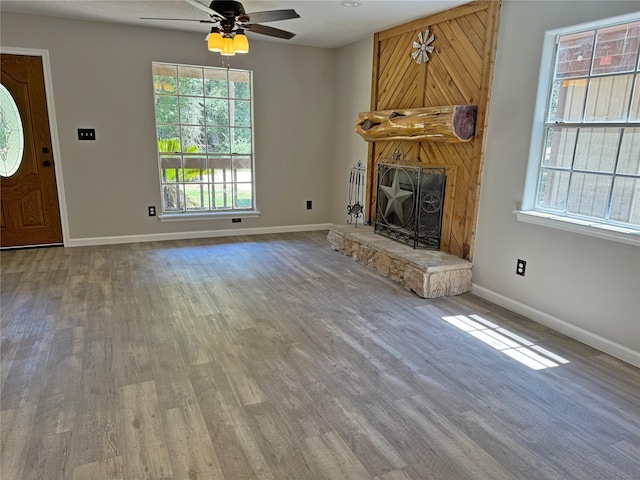 10 Walnut Loop, Shepherd, TX 77371 - unfurnished living room with wood finished floors, ceiling fan, plenty of natural light, and a fireplace