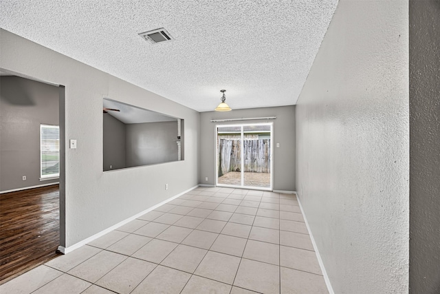 1043 Sierra Shadows Dr, Katy, TX 77450 - spare room featuring a textured ceiling, baseboards, a textured wall, and light tile patterned floors