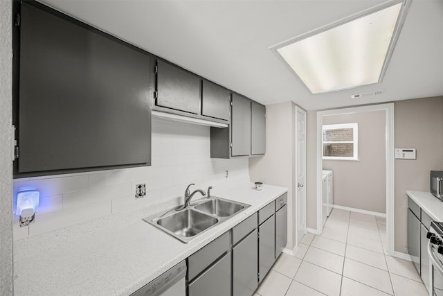 1043 Sierra Shadows Dr, Katy, TX 77450 - kitchen featuring a sink, light tile patterned flooring, light countertops, tasteful backsplash, and baseboards