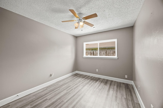 1043 Sierra Shadows Dr, Katy, TX 77450 - spare room featuring wood finished floors, a textured ceiling, a ceiling fan, and baseboards