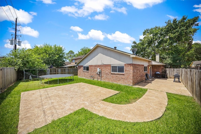 1043 Sierra Shadows Dr, Katy, TX 77450 - rear view of house with a trampoline, brick siding, a patio area, and a chimney