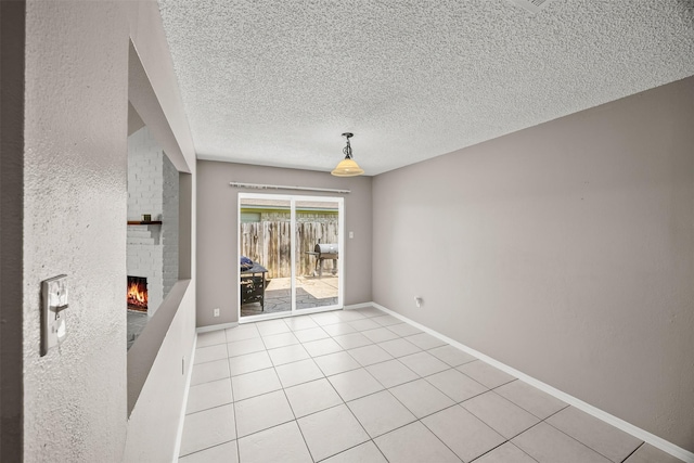 1043 Sierra Shadows Dr, Katy, TX 77450 - unfurnished living room featuring a fireplace, a textured ceiling, light tile patterned flooring, and baseboards