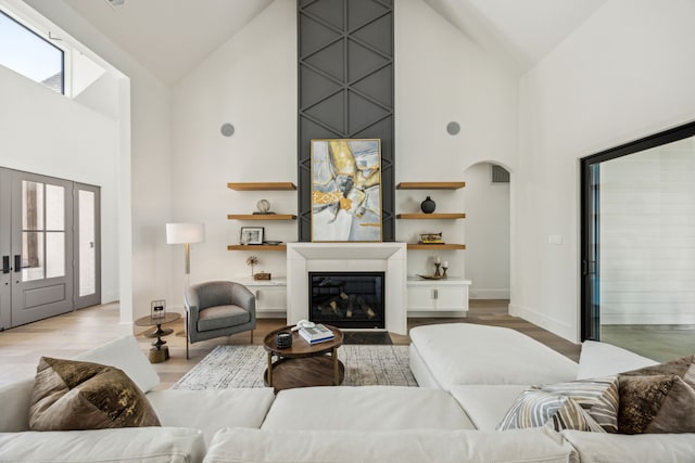 7310 Jalna St, Houston, TX 77055 - living area featuring high vaulted ceiling, a large fireplace, wood finished floors, arched walkways, and baseboards