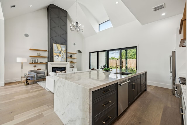 7310 Jalna St, Houston, TX 77055 - kitchen featuring a sink, high vaulted ceiling, dishwasher, light wood-style floors, and light stone counters