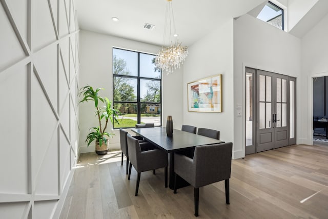 7310 Jalna St, Houston, TX 77055 - dining space featuring light wood-style floors, a chandelier, a towering ceiling, recessed lighting, and baseboards