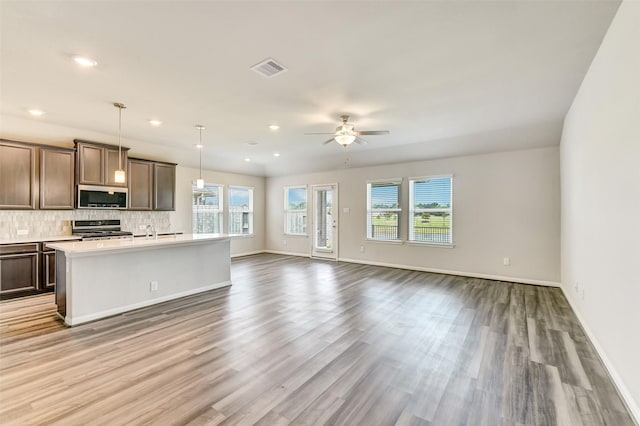 1210 Oak Barrel Run, Richmond, TX 77406 - kitchen featuring appliances with stainless steel finishes, ceiling fan, light wood-type flooring, light countertops, and baseboards