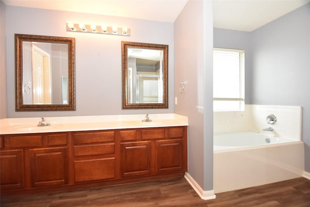 9619 Babbling Spring Ct, Tomball, TX 77375 - full bath with wood finished floors, a garden tub, double vanity, and baseboards