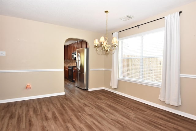 9619 Babbling Spring Ct, Tomball, TX 77375 - unfurnished dining area featuring arched walkways, a chandelier, dark wood-style floors, and baseboards