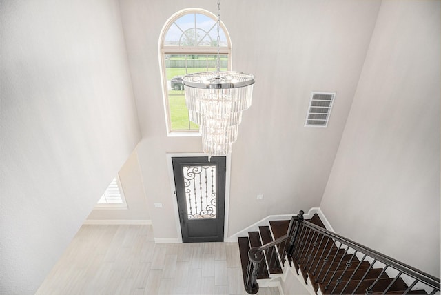 11503 Kings Point Blvd, Mont Belvieu, TX 77535 - foyer entrance featuring a chandelier, healthy amount of natural light, a high ceiling, baseboards, and stairs