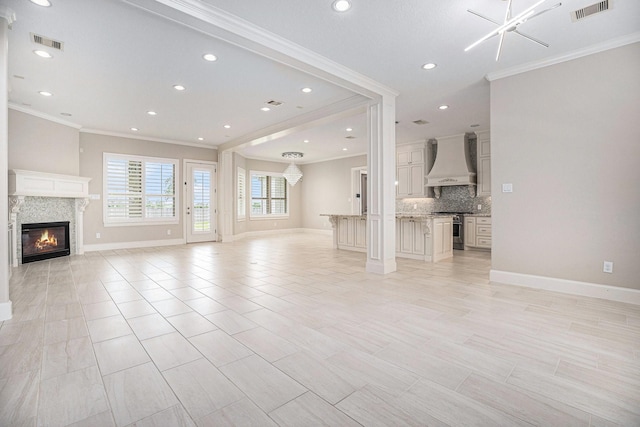 11503 Kings Point Blvd, Mont Belvieu, TX 77535 - unfurnished living room featuring crown molding, a glass covered fireplace, baseboards, and recessed lighting