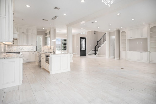 11503 Kings Point Blvd, Mont Belvieu, TX 77535 - kitchen featuring ornamental molding, recessed lighting, backsplash, an island with sink, and white cabinets